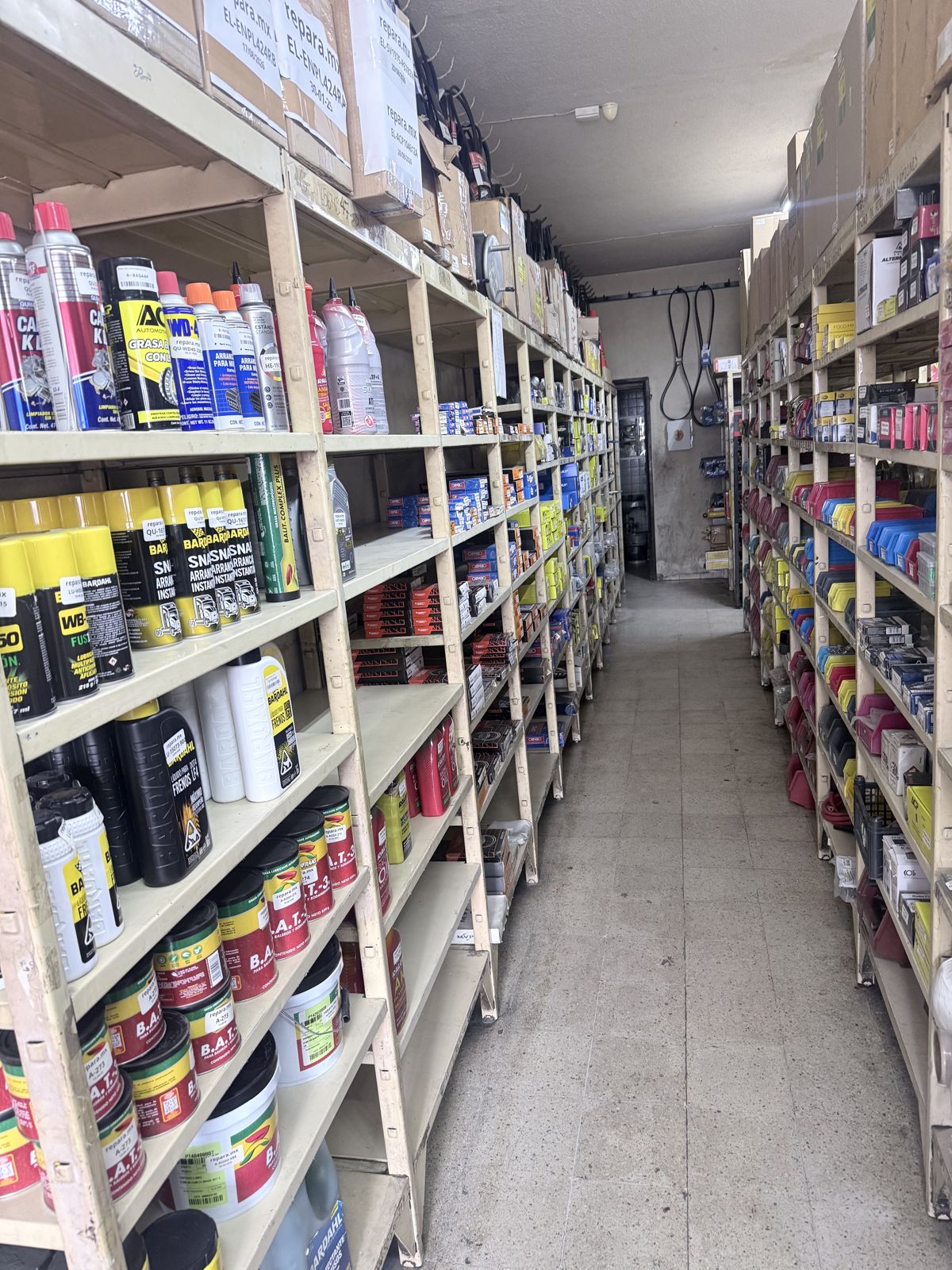 Pasillo de la refaccionaria con anaqueles llenos de aditivos, lubricantes y refacciones